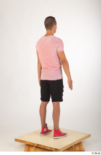 Colin black shorts clothing pink t shirt red shoes standing…